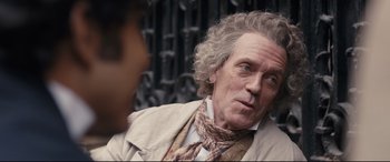 Movie still from “The Personal History of David Copperfield” (2019), directed by Armando Iannucci – An older man wearing a jacket and a neck tie; Close Up shot, Over the shoulder angle