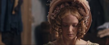 Movie still from “The Personal History of David Copperfield” (2019), directed by Armando Iannucci – A woman in a hat with flowers in her hair; Close Up shot, Over the shoulder angle