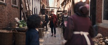 Movie still from “The Personal History of David Copperfield” (2019), directed by Armando Iannucci – A group of people walking down a street; Wide shot, Over the shoulder angle