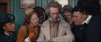 Movie still from “The Personal History of David Copperfield” (2019), directed by Armando Iannucci – A group of people standing next to each other in a room; Medium shot, High angle