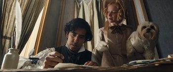 Movie still from “The Personal History of David Copperfield” (2019), directed by Armando Iannucci – A man and a woman in period dress writing on a piece of paper; Medium shot, Low angle