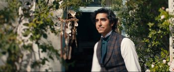 Movie still from “The Personal History of David Copperfield” (2019), directed by Armando Iannucci – A man in a vest and tie standing in front of a building; Medium shot, Over the shoulder angle