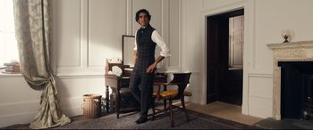 Movie still from “The Personal History of David Copperfield” (2019), directed by Armando Iannucci – A man standing in front of a mirror in a room; Medium shot, Low angle