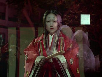 Movie still from “The Pillow Book” (1995), directed by Peter Greenaway – A woman in a red and white kimono holding a wooden stick; Medium shot, Over the shoulder angle