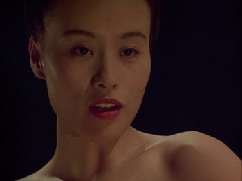 Movie still from “The Pillow Book” (1995), directed by Peter Greenaway – A beautiful woman with red lipstick looking at the camera; Close Up shot, Low angle