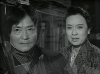 Movie still from “The Pillow Book” (1995), directed by Peter Greenaway – A man and a woman standing next to each other; Close Up shot, Low angle