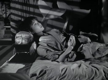 Movie still from “The Pillow Book” (1995), directed by Peter Greenaway – A young boy laying on a bed in a room; Medium shot, High angle