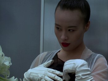 Movie still from “The Pillow Book” (1995), directed by Peter Greenaway – A woman wearing white gloves and a black top; Close Up shot, Low angle