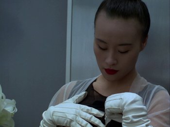Movie still from “The Pillow Book” (1995), directed by Peter Greenaway – A woman in white gloves looking down at her gloves; Close Up shot, Low angle