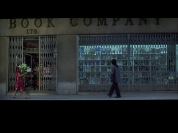 A person walking down the street in front of a book company