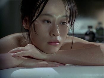 Movie still from “The Pillow Book” (1995), directed by Peter Greenaway – A woman with wet hair laying on a bathtub; Close Up shot, High angle
