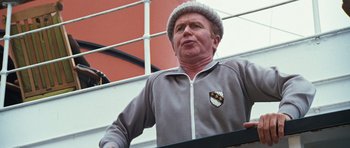 Movie still from “The Poseidon Adventure” (1972), directed by Ronald Neame – An older man wearing a gray jacket and a hat; Close Up shot, Low angle
