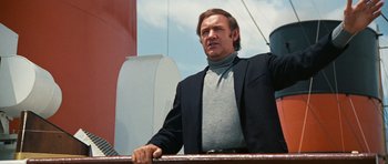 Movie still from “The Poseidon Adventure” (1972), directed by Ronald Neame – A man standing on top of a boat in the water; Medium shot, Low angle