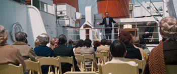 Movie still from “The Poseidon Adventure” (1972), directed by Ronald Neame – A man standing on top of a boat in front of a crowd; Wide shot, High angle