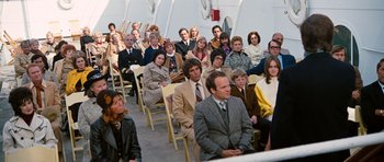 Movie still from “The Poseidon Adventure” (1972), directed by Ronald Neame – A group of people sitting in chairs in a room; Wide shot, High angle