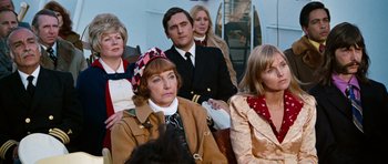 Movie still from “The Poseidon Adventure” (1972), directed by Ronald Neame – A group of people sitting in a row on a boat; Medium shot, High angle