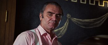 Movie still from “The Poseidon Adventure” (1972), directed by Ronald Neame – An older man in a pink dress shirt and tie; Close Up shot, Low angle