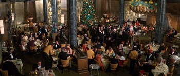Movie still from “The Poseidon Adventure” (1972), directed by Ronald Neame – A group of people sitting at tables in front of a christmas tree; Extreme Wide shot, High angle