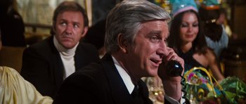 Movie still from “The Poseidon Adventure” (1972), directed by Ronald Neame – An older man talking on a cell phone; Close Up shot, Over the shoulder angle