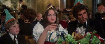 Movie still from “The Poseidon Adventure” (1972), directed by Ronald Neame – A woman wearing a hat and holding a glass of wine; Medium shot, Over the shoulder angle