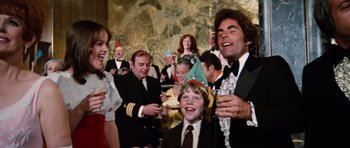 Movie still from “The Poseidon Adventure” (1972), directed by Ronald Neame – A group of people in formal wear are drinking champagne; Medium shot, Overhead angle