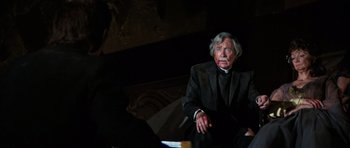 Movie still from “The Poseidon Adventure” (1972), directed by Ronald Neame – An older man sitting in a chair in a dark room; Medium shot, Over the shoulder angle