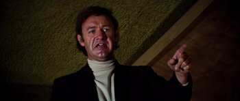 Movie still from “The Poseidon Adventure” (1972), directed by Ronald Neame – A man in a black jacket and a white sweater; Close Up shot, Low angle