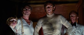 Movie still from “The Poseidon Adventure” (1972), directed by Ronald Neame – Two men standing next to each other in a room; Medium shot, Low angle