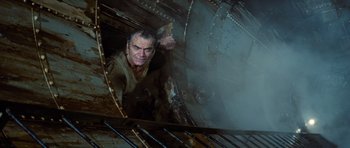 Movie still from “The Poseidon Adventure” (1972), directed by Ronald Neame – A man is climbing up the side of a train car; Medium shot, Overhead angle