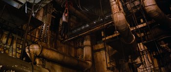Movie still from “The Poseidon Adventure” (1972), directed by Ronald Neame – A man hanging from a metal pole inside a building; Wide shot, High angle
