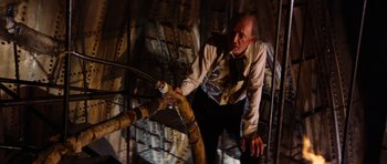 Movie still from “The Poseidon Adventure” (1972), directed by Ronald Neame – A man in a suit and tie holding onto a rope; Medium shot, Overhead angle