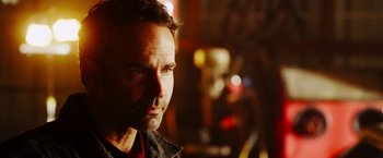 Movie still from “The Prince” (2014), directed by Brian A. Miller – A person wearing a black jacket; Close Up shot, Over the shoulder angle