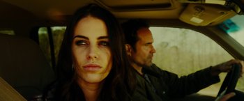 Movie still from “The Prince” (2014), directed by Brian A. Miller – A man and a woman sitting in a car looking at the camera; Close Up shot, Low angle