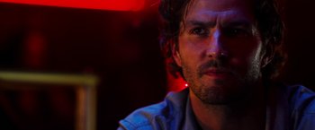 Movie still from “The Prince” (2014), directed by Brian A. Miller – A person wearing a blue shirt; Close Up shot, Over the shoulder angle