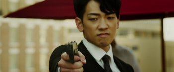 Movie still from “The Prince” (2014), directed by Brian A. Miller – A man in a suit and tie holding a gun in his hand; Close Up shot, Low angle