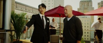 Movie still from “The Prince” (2014), directed by Brian A. Miller – A man standing next to another man in a suit; Medium shot, Over the shoulder angle