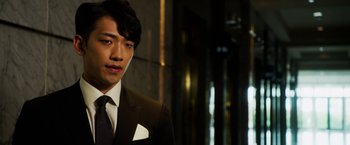 Movie still from “The Prince” (2014), directed by Brian A. Miller – A man in a suit and tie standing in front of a building; Close Up shot, Low angle