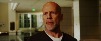 Movie still from “The Prince” (2014), directed by Brian A. Miller – A man with a beard and a white t - shirt; Close Up shot, Over the shoulder angle