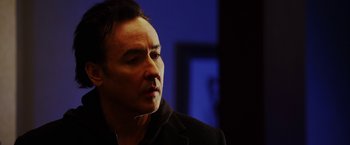 Movie still from “The Prince” (2014), directed by Brian A. Miller – A person wearing a black jacket; Close Up shot, Low angle