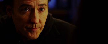 Movie still from “The Prince” (2014), directed by Brian A. Miller – A man's face with a dark background; Close Up shot, Over the shoulder angle