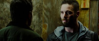 Movie still from “The Prince” (2014), directed by Brian A. Miller – A man with a beard is standing next to another man; Close Up shot, Over the shoulder angle