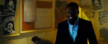 Movie still from “The Prince” (2014), directed by Brian A. Miller – A man in a blue shirt and a suit smiling for the camera; Close Up shot, Over the shoulder angle