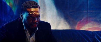 Movie still from “The Prince” (2014), directed by Brian A. Miller – A person wearing a suit and tie; Close Up shot, Over the shoulder angle