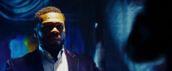 Movie still from “The Prince” (2014), directed by Brian A. Miller – A person wearing a suit and tie; Close Up shot, Low angle