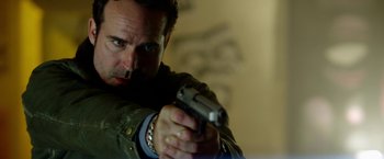 Movie still from “The Prince” (2014), directed by Brian A. Miller – A person holding a gun; Close Up shot, Over the shoulder angle
