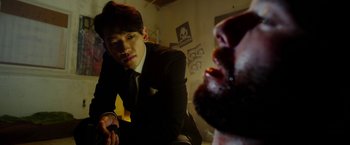 Movie still from “The Prince” (2014), directed by Brian A. Miller – A man in a suit and tie looking at another man in a beard; Close Up shot, Over the shoulder angle