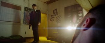 Movie still from “The Prince” (2014), directed by Brian A. Miller – A man in a suit standing in front of a mirror; Wide shot, Low angle