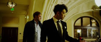 Movie still from “The Prince” (2014), directed by Brian A. Miller – Two men in suits and ties standing next to each other; Medium shot, Low angle