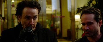 Movie still from “The Prince” (2014), directed by Brian A. Miller – A person holding a cell phone; Close Up shot, Over the shoulder angle