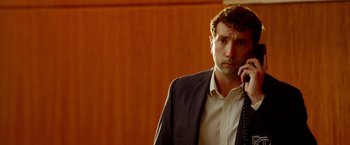 Movie still from “The Prince” (2014), directed by Brian A. Miller – A man in a suit and tie talking on a cell phone; Close Up shot, Low angle